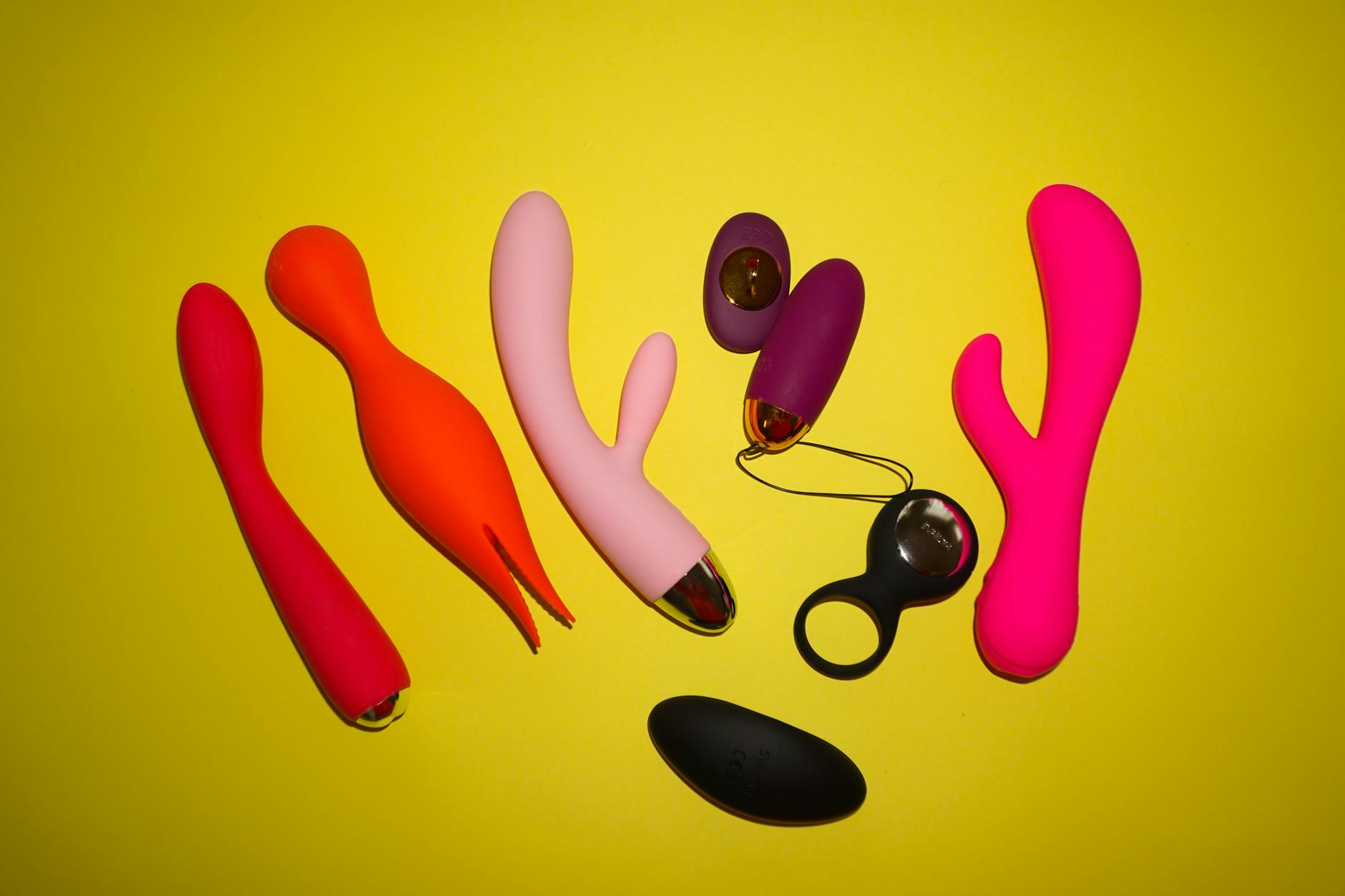 Hand holding a modern vibrator against a minimalist purple background, representing sensory reconnection
